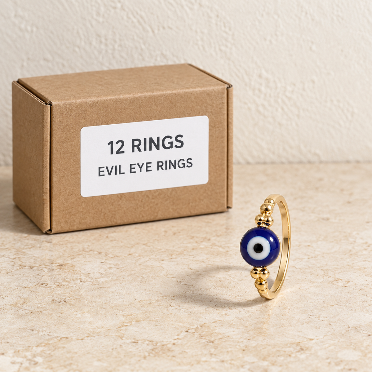 Rings — Box of 12 — 12 × Evil Eye Rings. Representative samples beside illustrative wholesale carton.