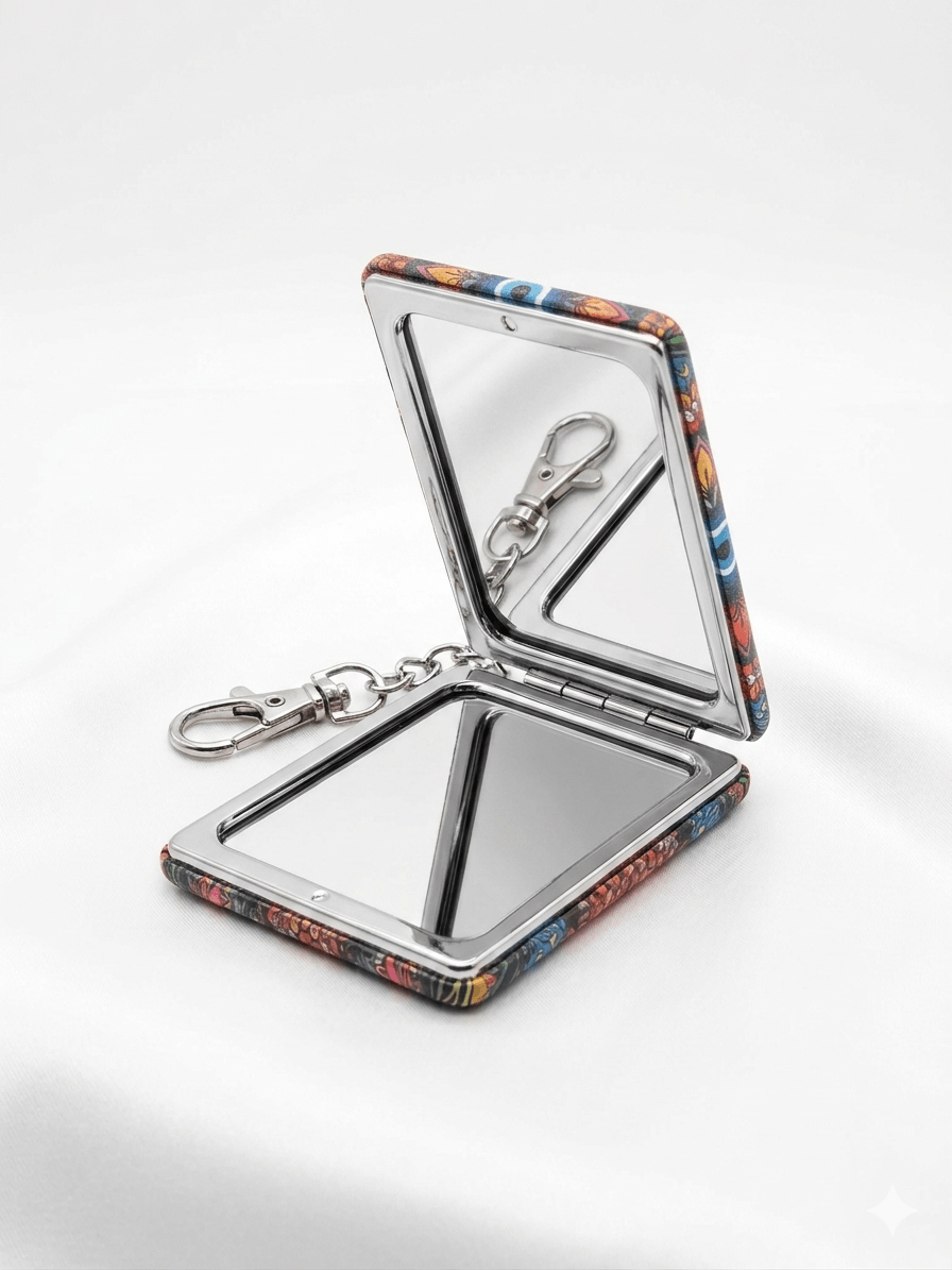 Evil Eye Compact Mirror Keychain with vibrant patterns opened on a soft white background.