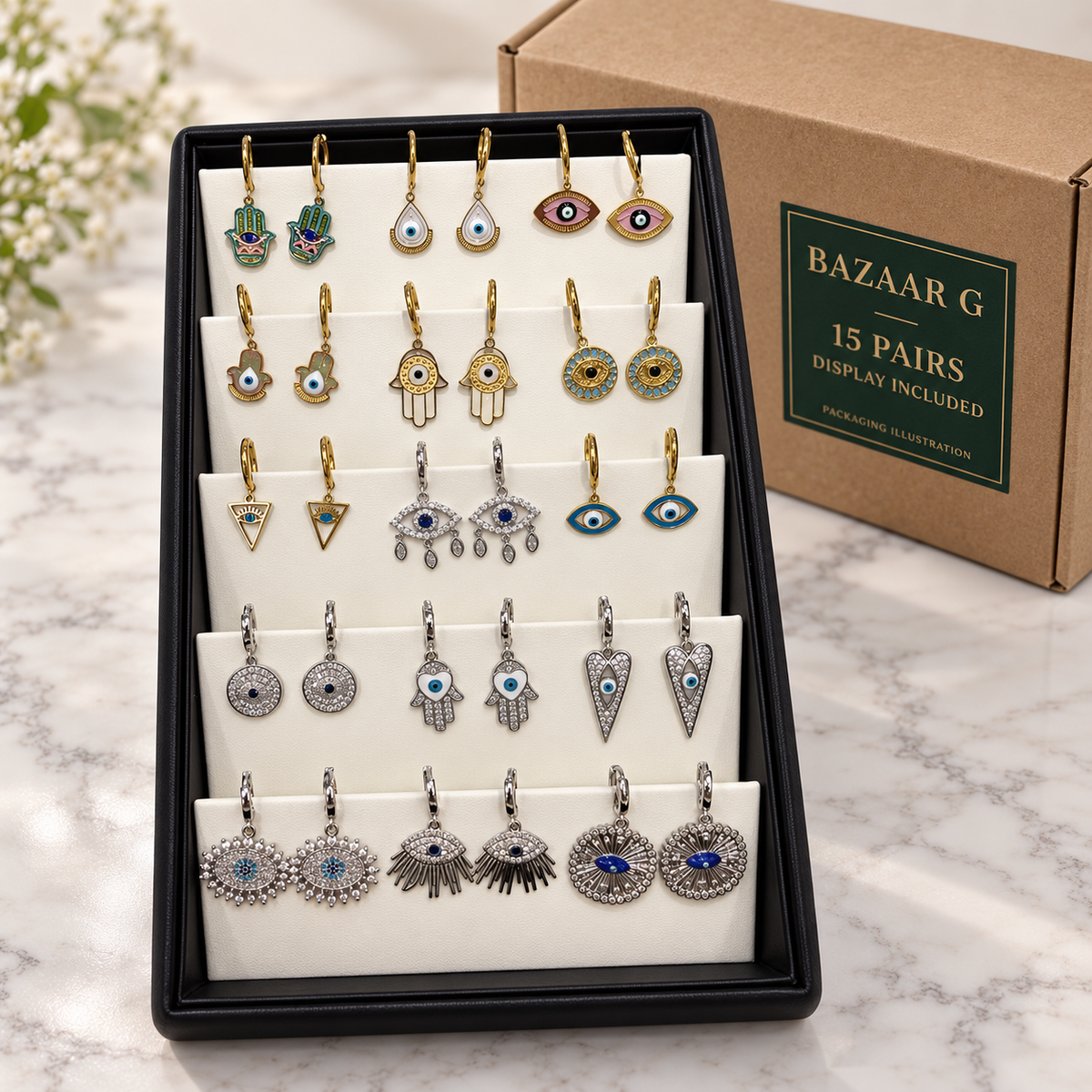 15 pairs of evil eye and Hamsa earrings in the included display tray beside an illustrative wholesale carton