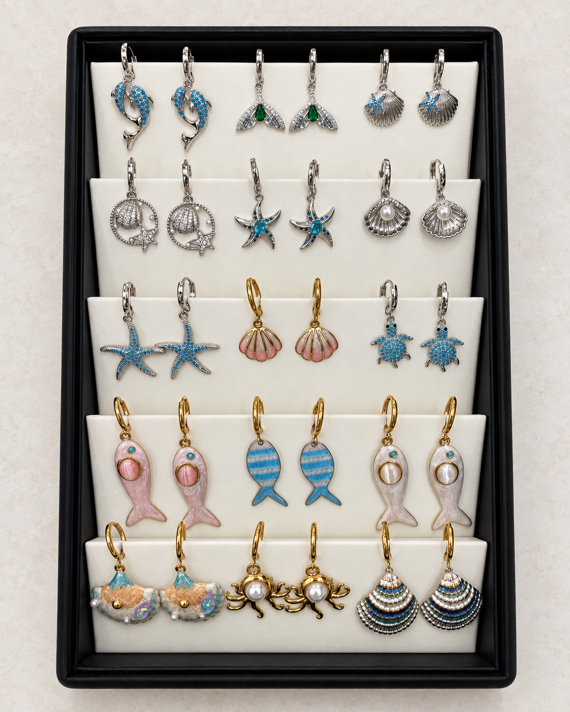 AI-retouched studio photograph of the ocean and sea-life earring display, 15 pairs with tray included
